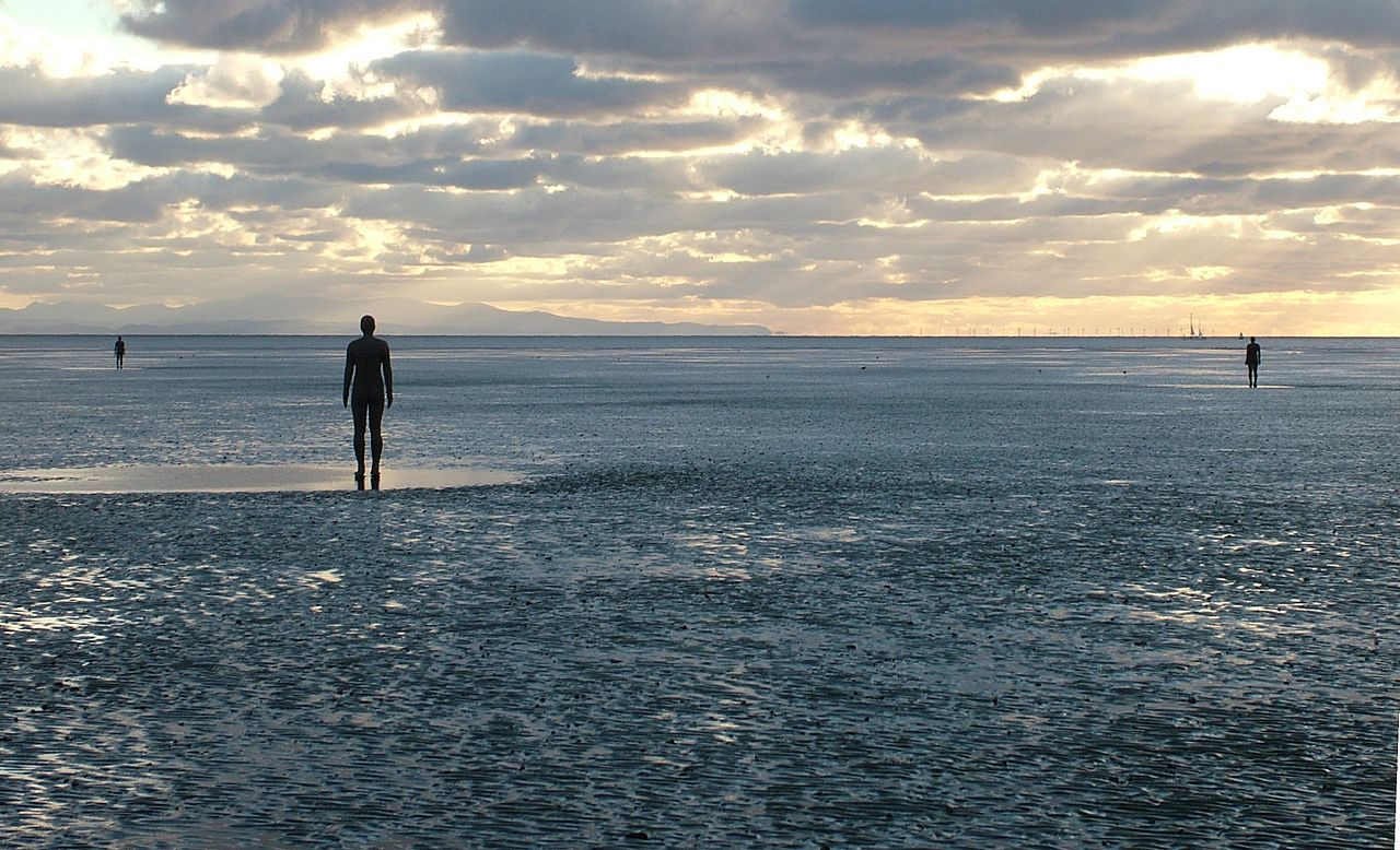 A beach scape with multiple life-size cast-iron moulds of the artists own body