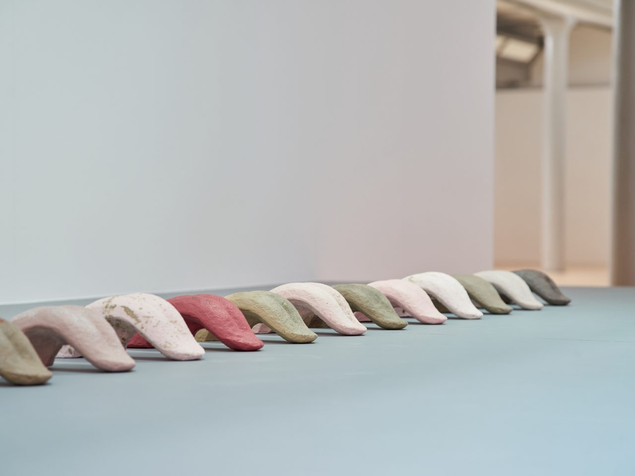 An installation of ceramic tounges, painted in white, green and red.