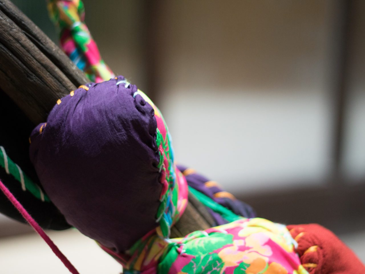 A close up of an abstract sculpture, made up of wrapped around colourful fabric and stitching
