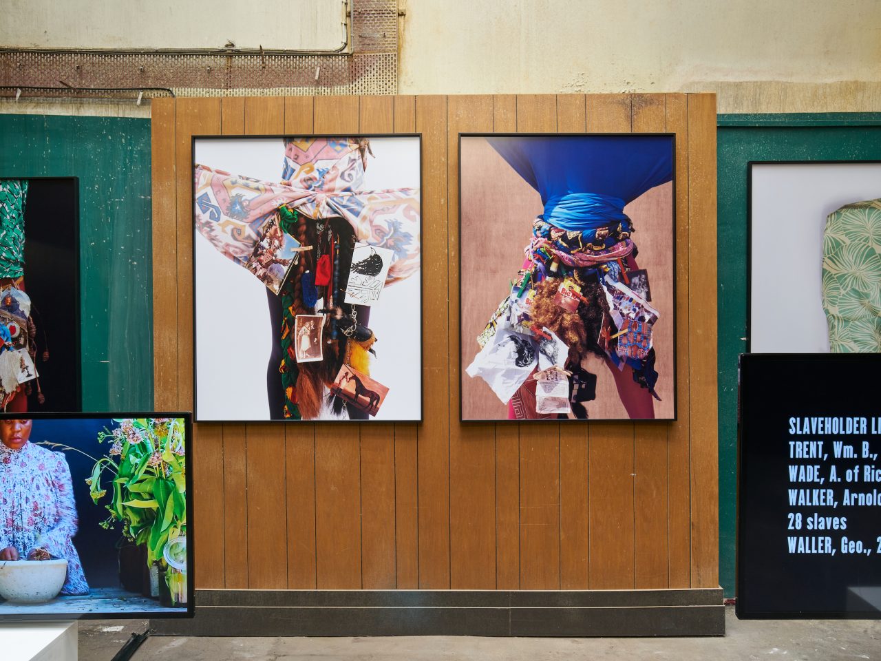 Four large flat fashion photographs on the walls of Cotton Exchange, there are also 2 screens in the foreground , one with information text and the other of a woman with her hands in a bowl. The space had dark green walls with a wooden space in the middle.