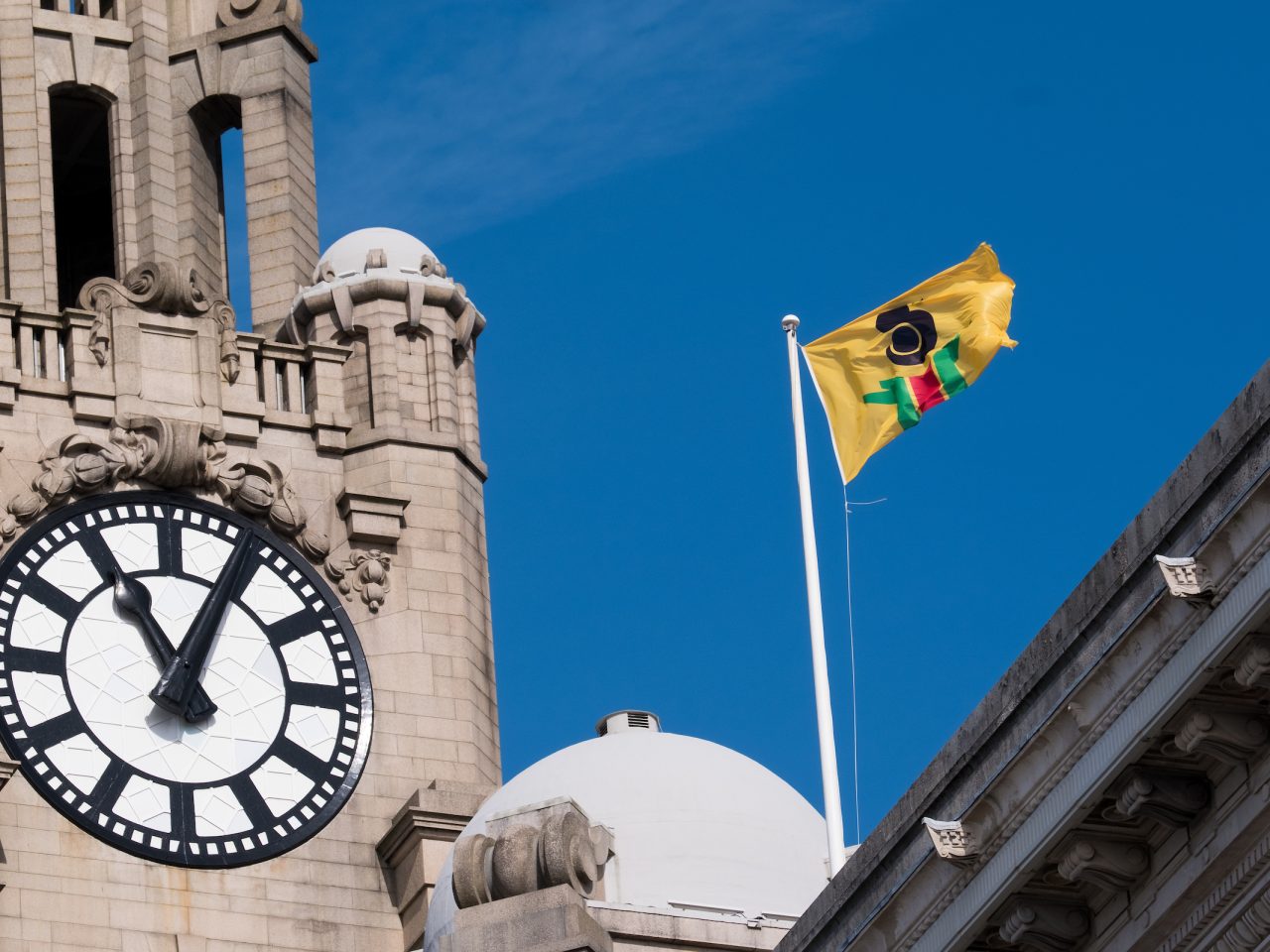 A flag designed by the artist, designed based on the colours of the african flag. The flag is yellow with a black green and red figure.