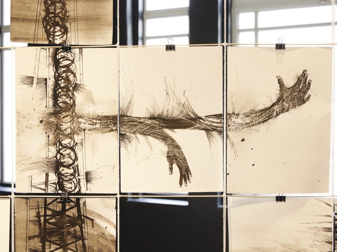 Black ink drawings on A4 paper showing hands and circular mark making. The papers are clipped together creating one larger artwork.
