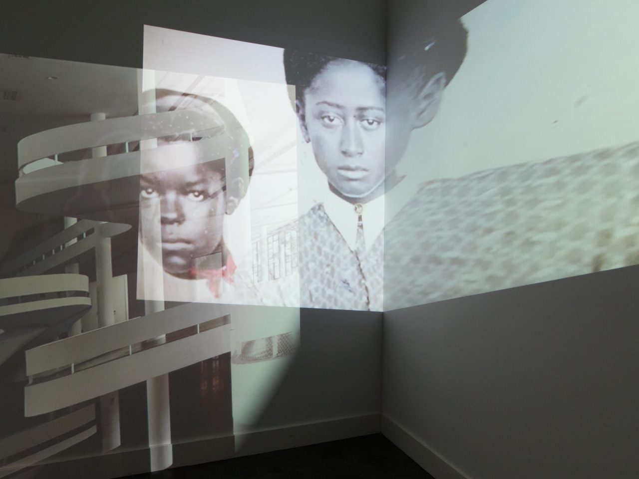 Projections overlapping each other in a blank white room.