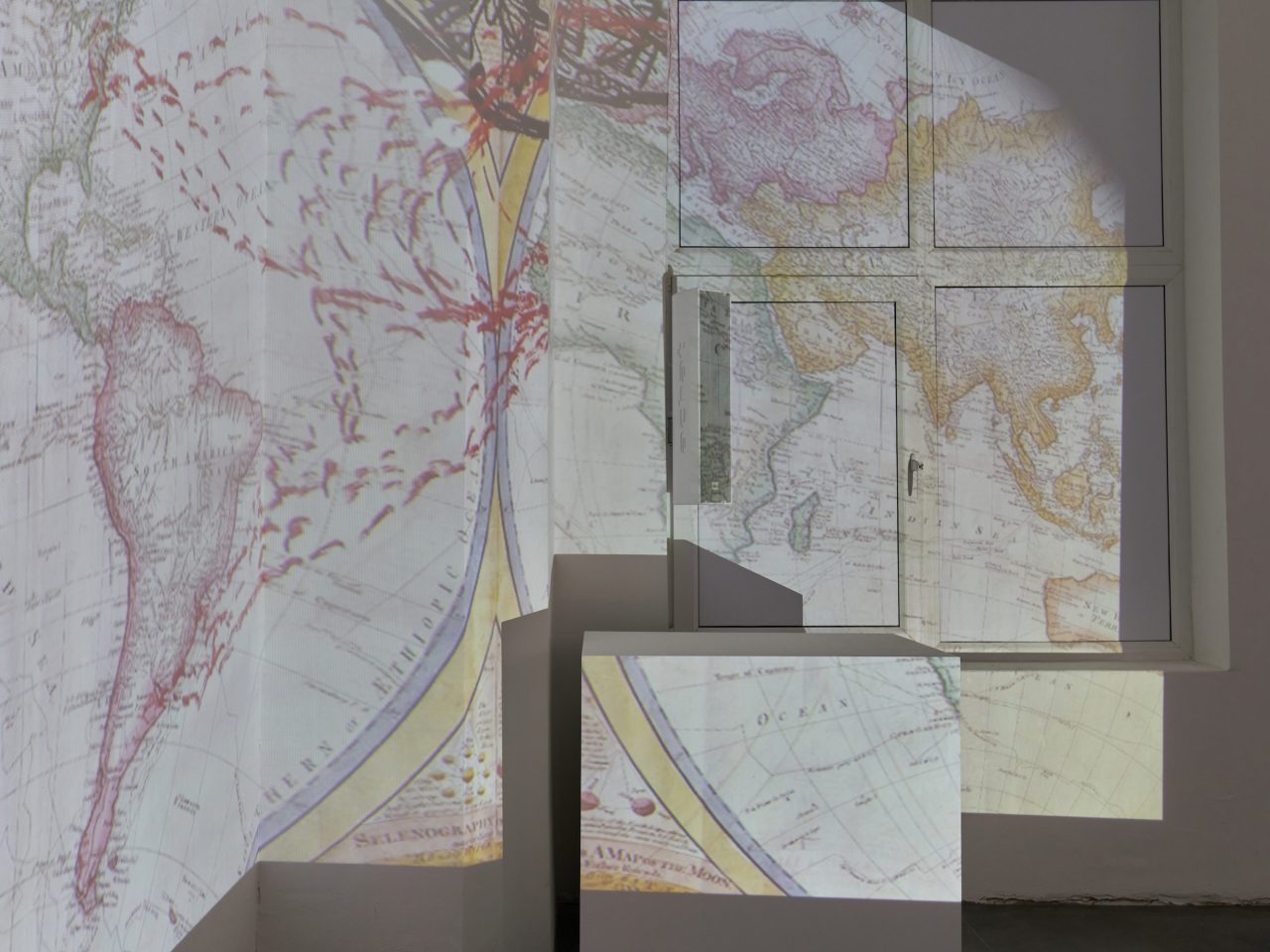 a projection of the map of the world, the projection is projected into the corner of a room.