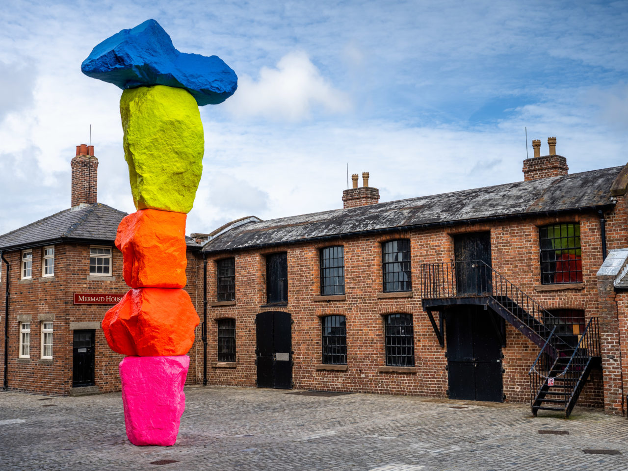 A 10-metre high sculpture on Liverpool’s waterfront, the sculpture consists of 5 vertically-stacked rocks painted in bright fluorescent colours